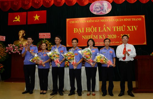 Đồng chí Mai Trung Thành (trái) và đồng chí Vũ Ngọc Tuất (phải) tặng hoa chúc mừng cấp ủy Chi bộ Viện Kiểm sát nhân dân quận nhiệm kỳ 2020 - 2025. (Ảnh: VM)